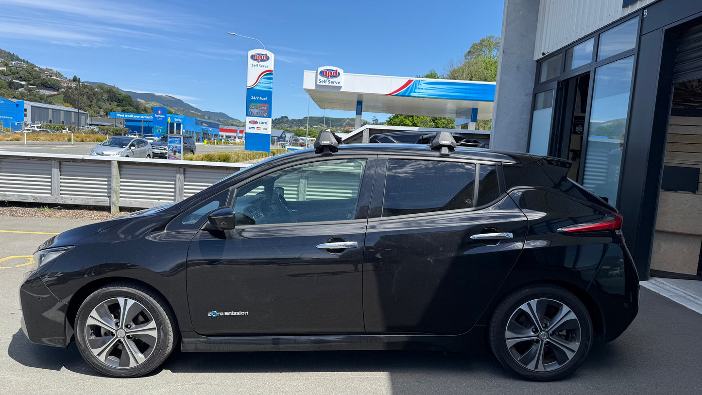 Black electric car parked at stoke equipment co with a clear blue sky.