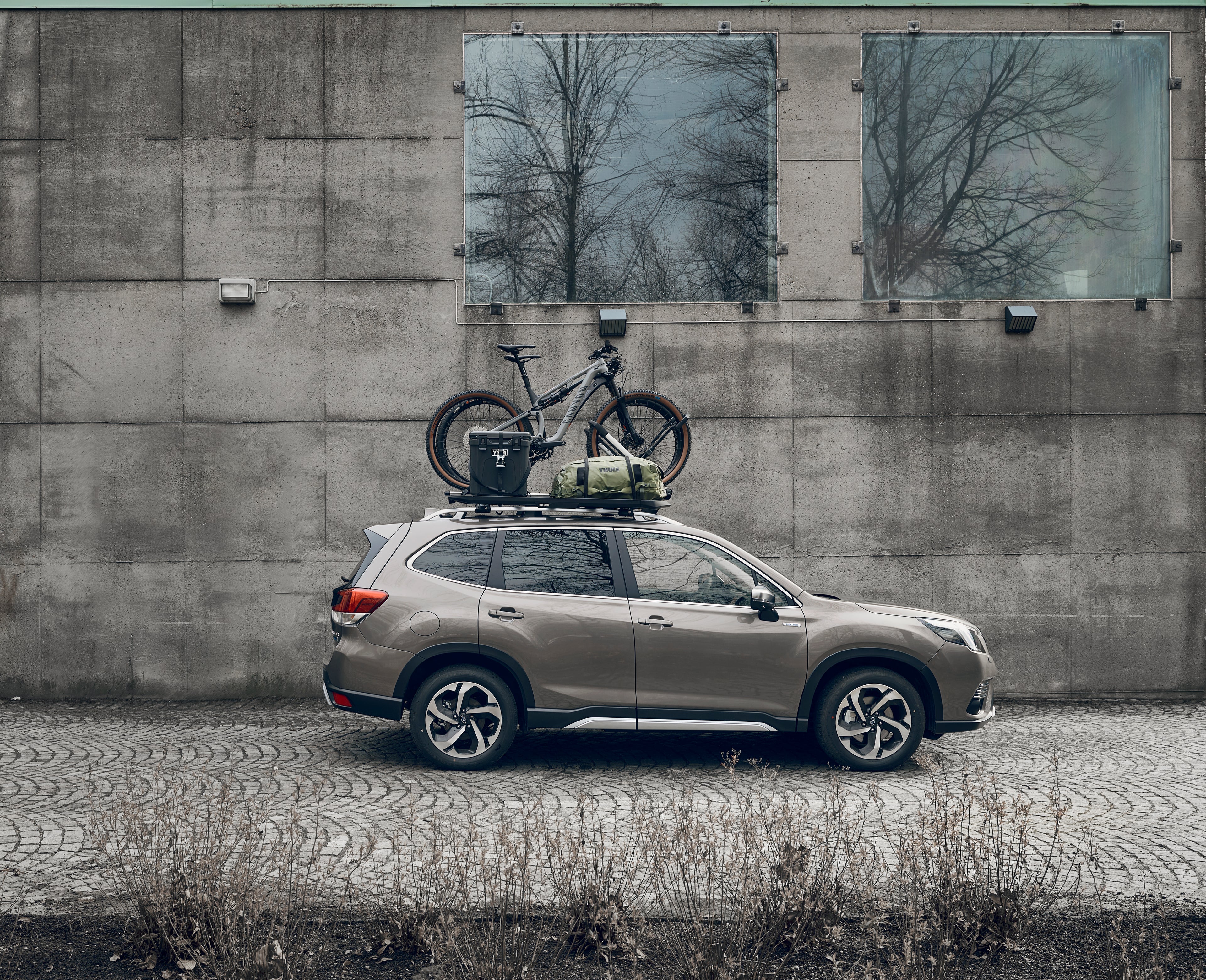 Subaru Forester with a Roof Rack on top, carrying a mountain bike, duffel bags and a cargo case