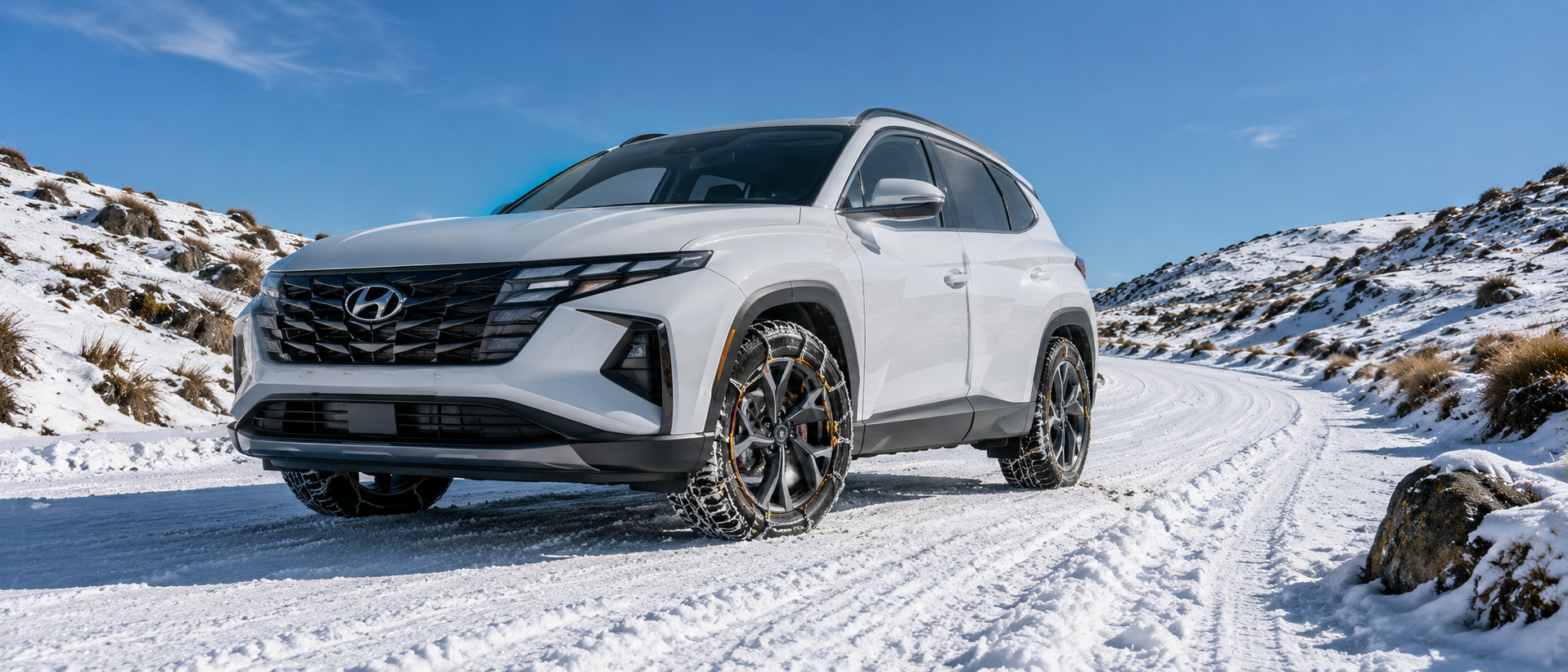 snowy alpine road with tussocks and rocks and blue  skies. Hyundai tucson with konig snow chains 