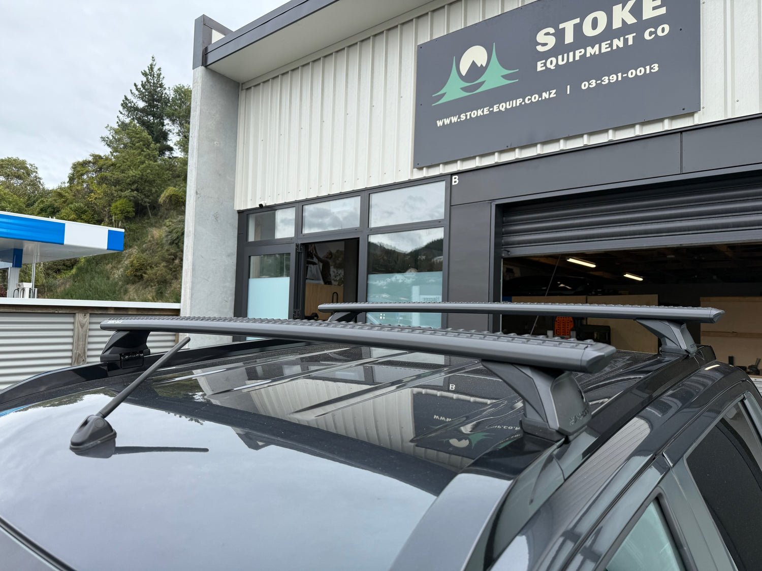 Car with Rhino-Rack RX200 roof rack in front of Stoke Equipment Co building