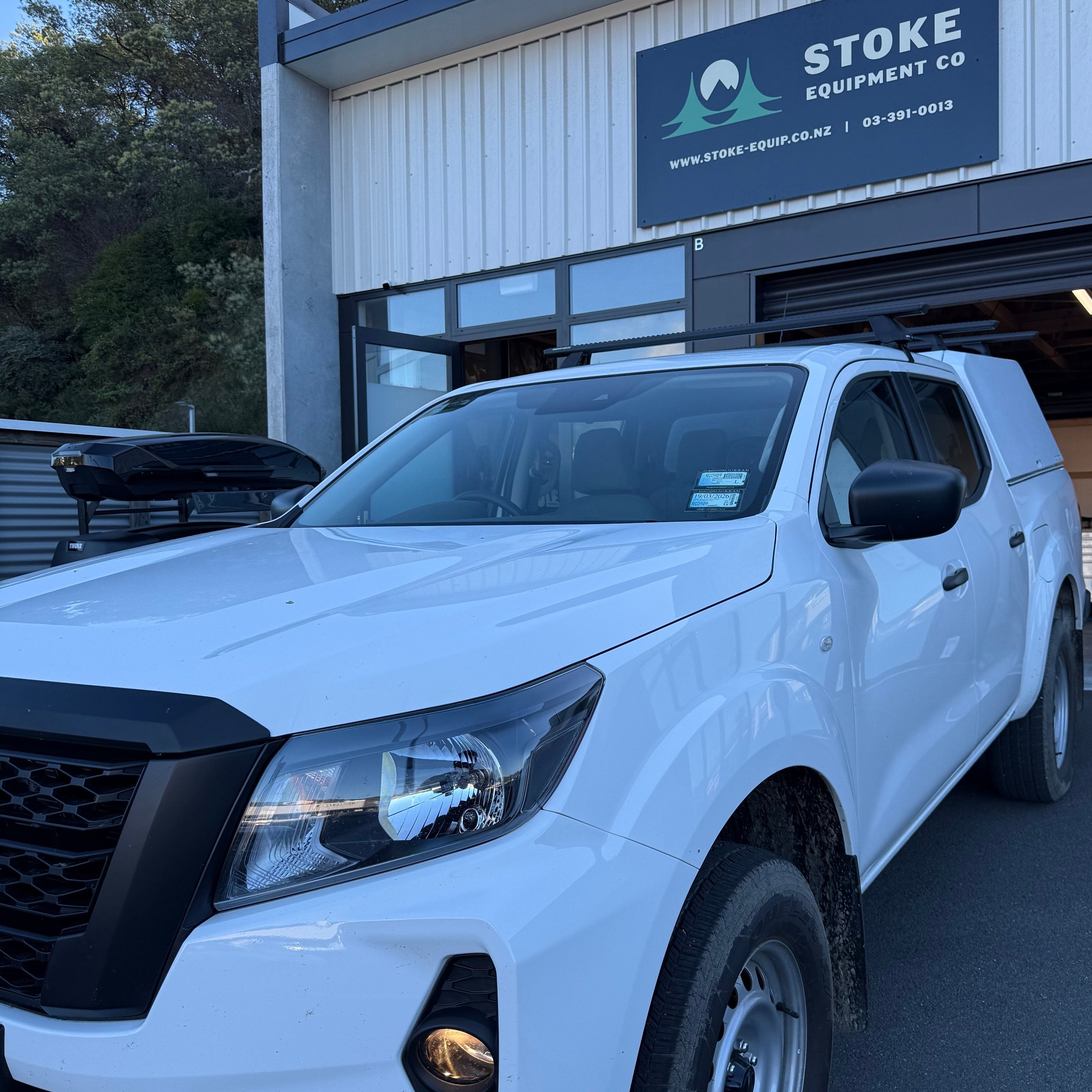 NIssan navara fitted with a rhino-rack 3 bar sportz roof rack system, parked in front of stoke equipment co official rhino-rack dealer based in nelson NZ 