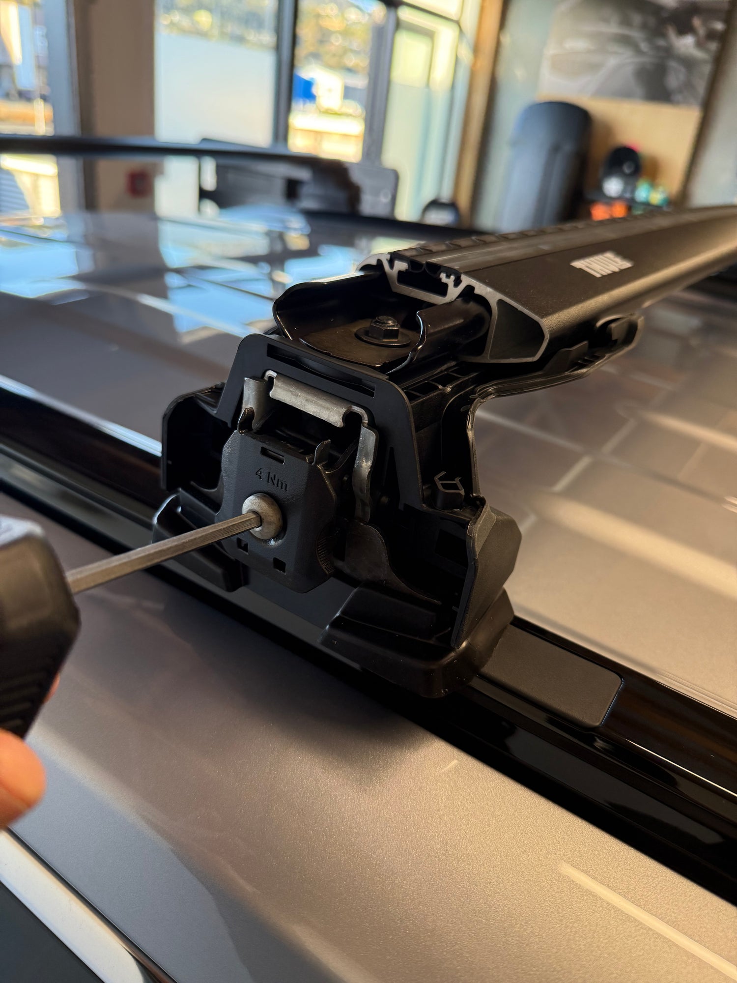 Close-up of a Thule Roof Rack system being adjusted with a tool at Stoke Equipment Co Nelson
