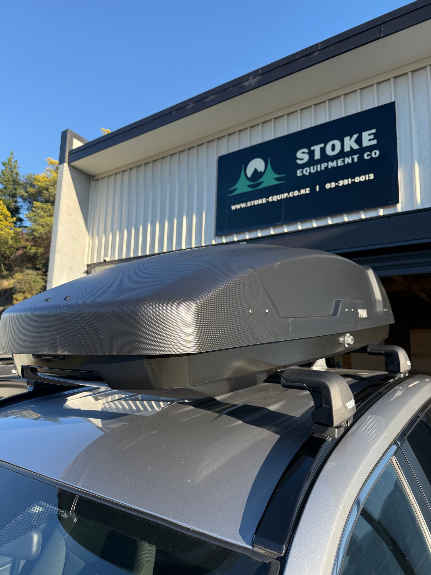Thule Force XT Roof Box mounted on a THule Roof rack system, parked outside Stoke Equipment Co Thule specialist store in Nelson NZ