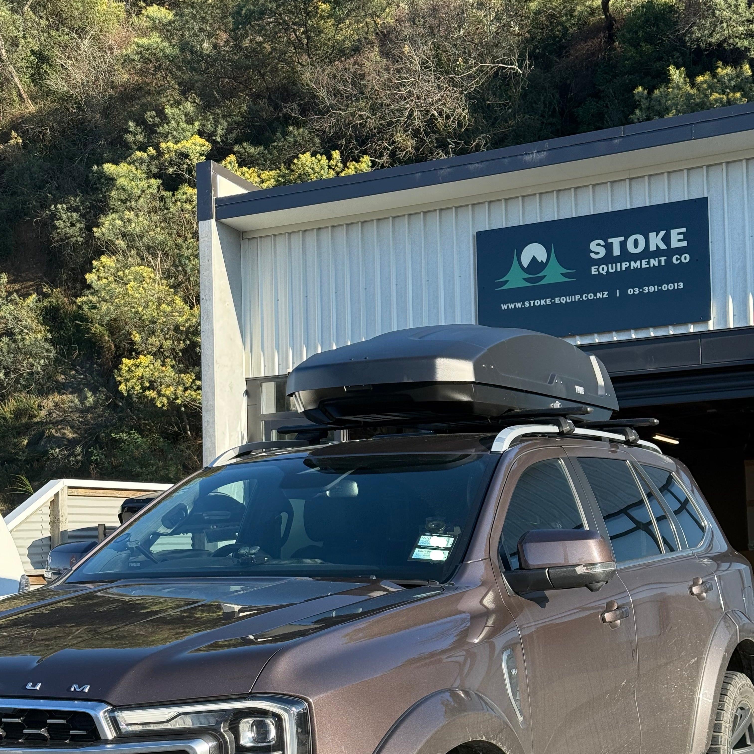 Car parked in front of a building with a sign that reads 'Stoke'.