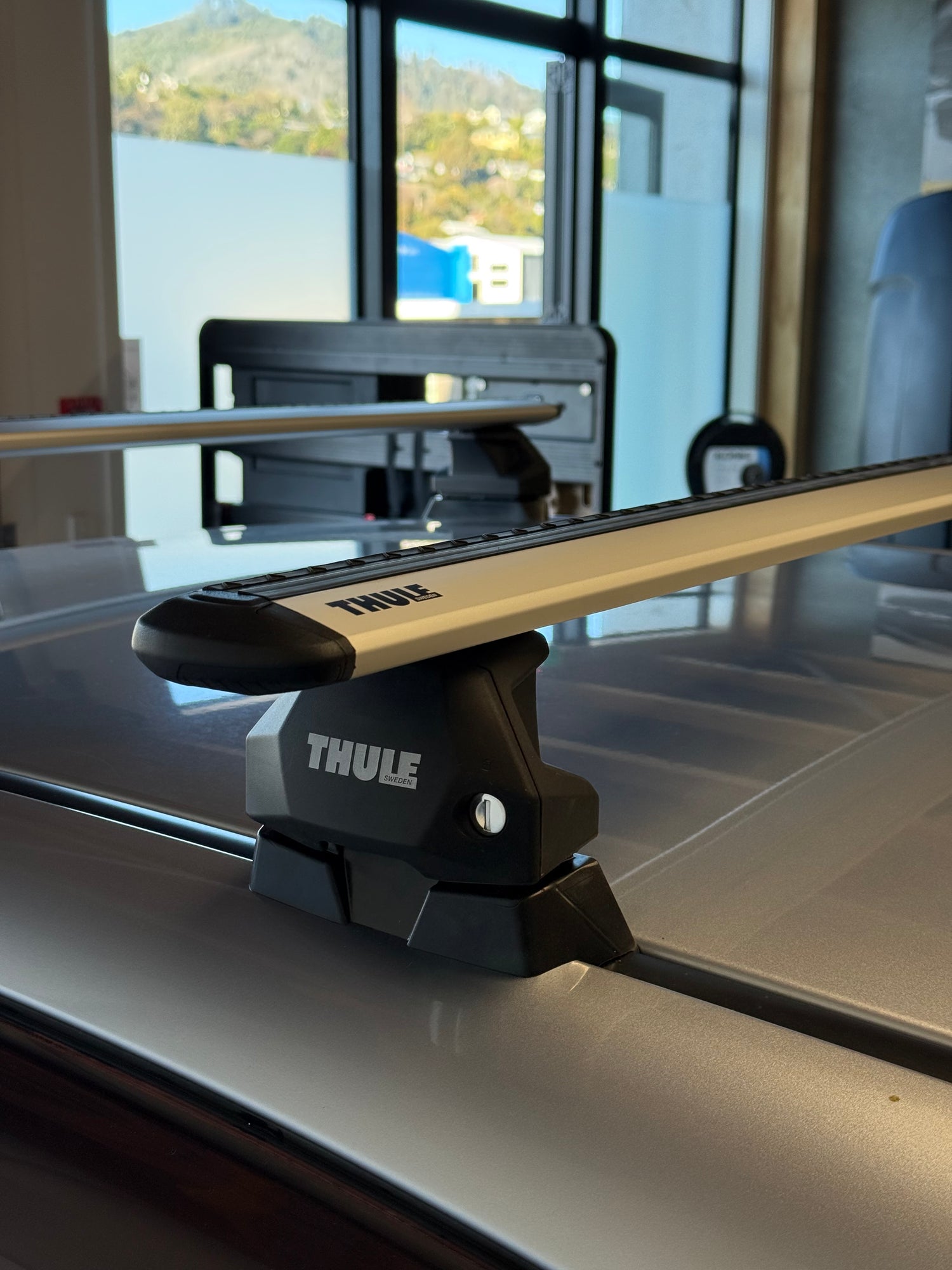 Close-up of a Thule wingbar evo silver roof rack attached to a vehicle with fixpoint mounts at stoke equipment co roof rack store in nelson new zealand