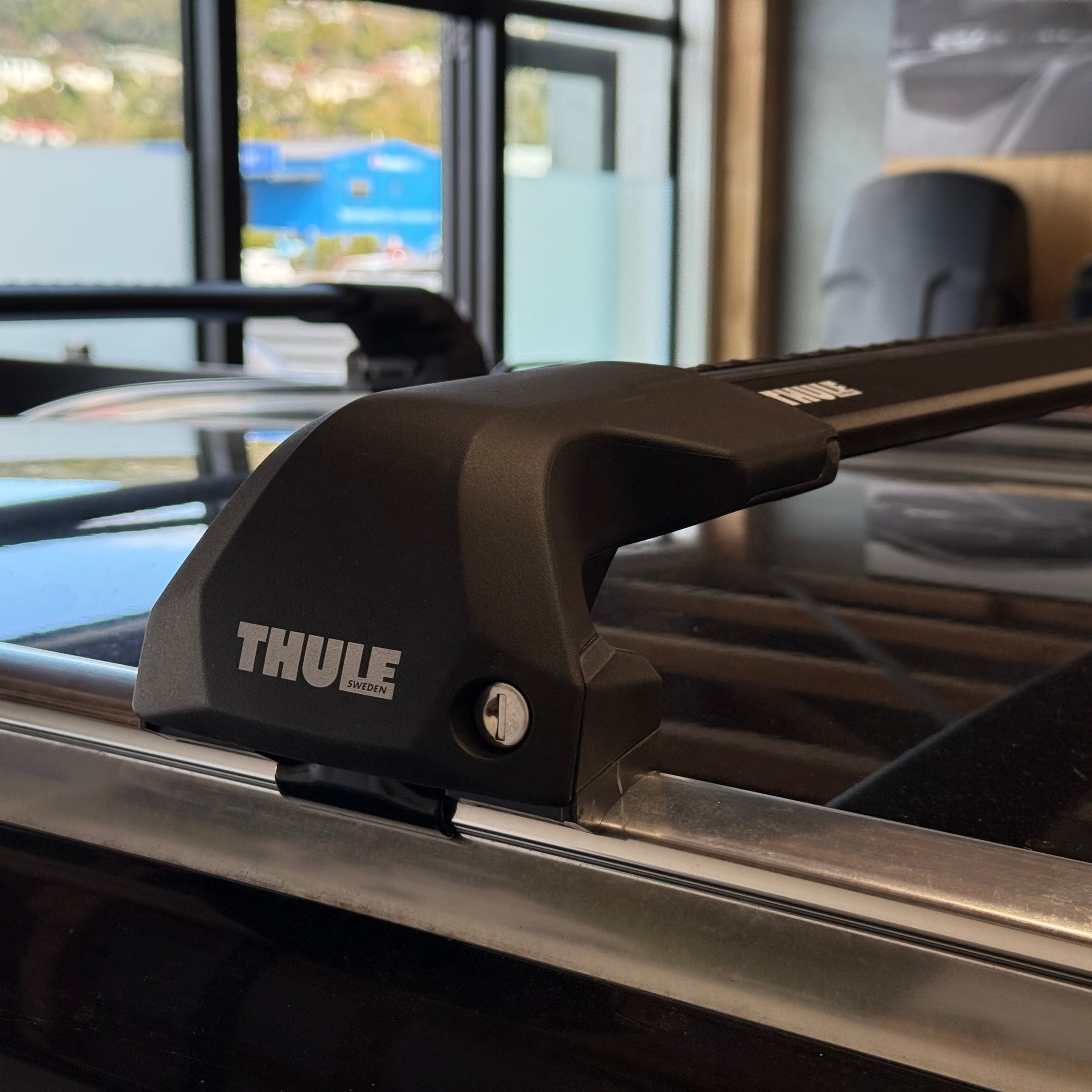 Thule roof rack system on a vehicle with a blurred indoor background