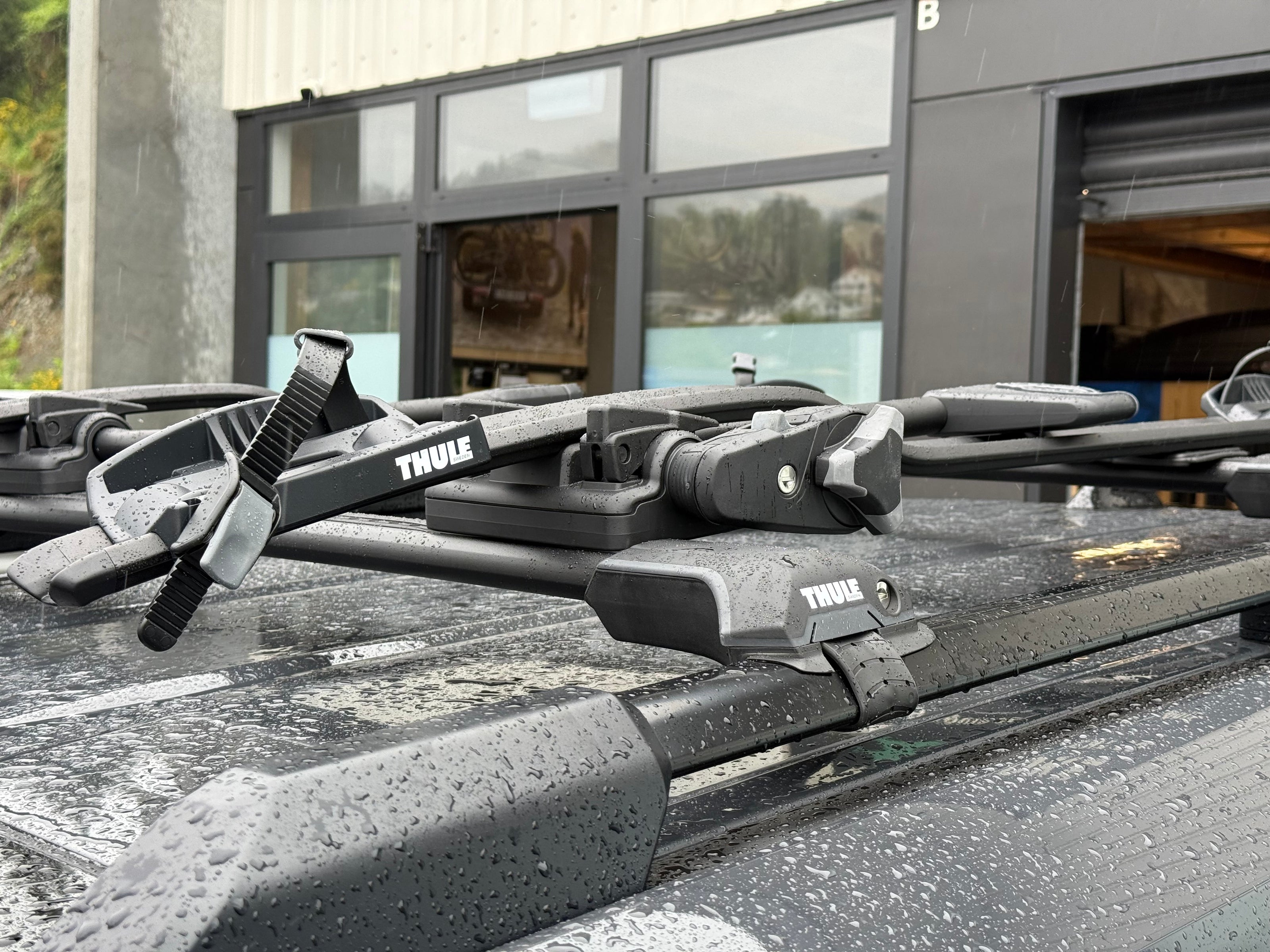 Thule wingbar edgeroof rack clamped to factory raised roof rails on vehicle