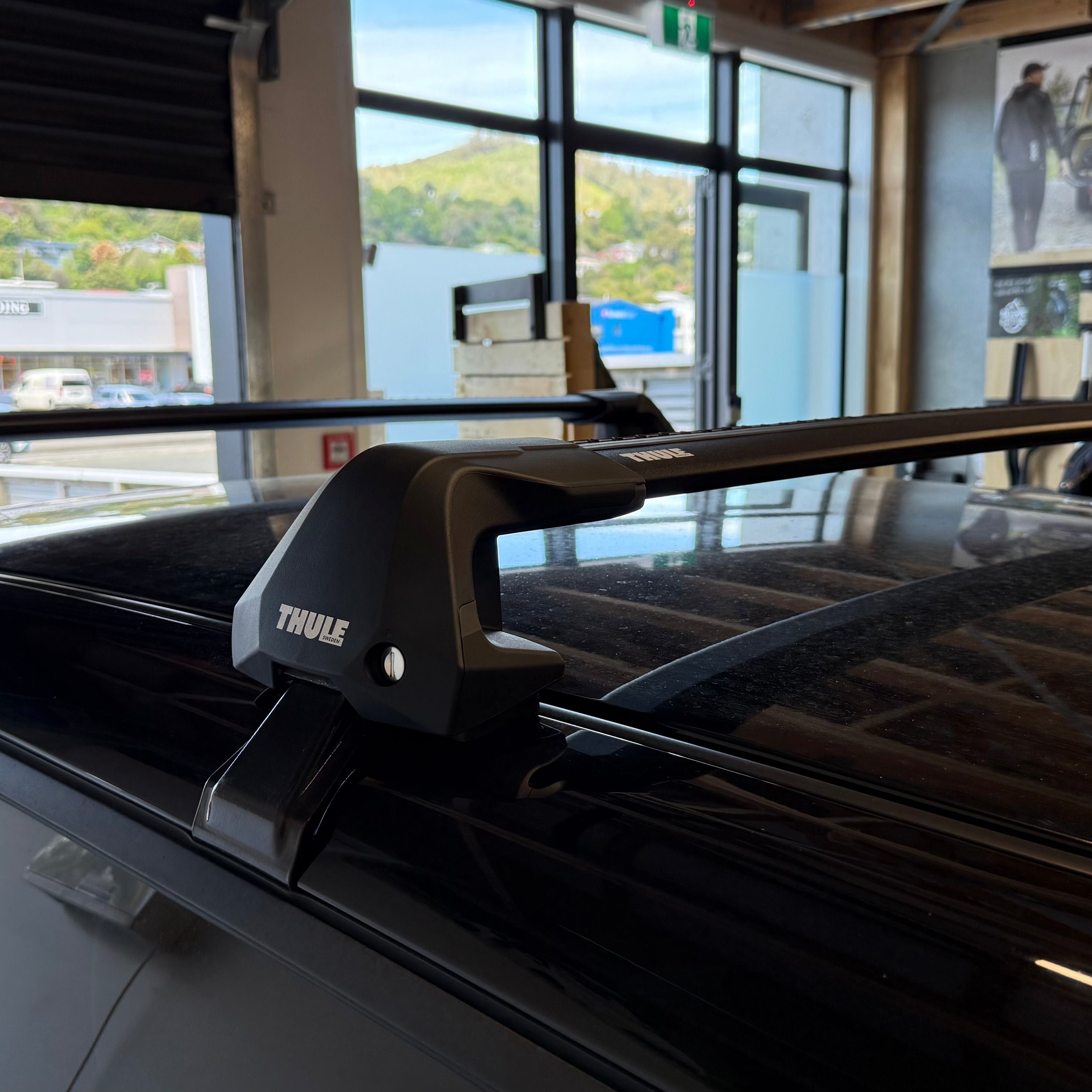 Thule 720500 WingBar Edge Clamp Mount roof rack mounted on a vehicle in a showroom setting