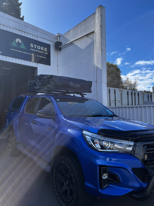 toyota hilux with rhino-rack roof racks and feldon shelter rooftop tent 44