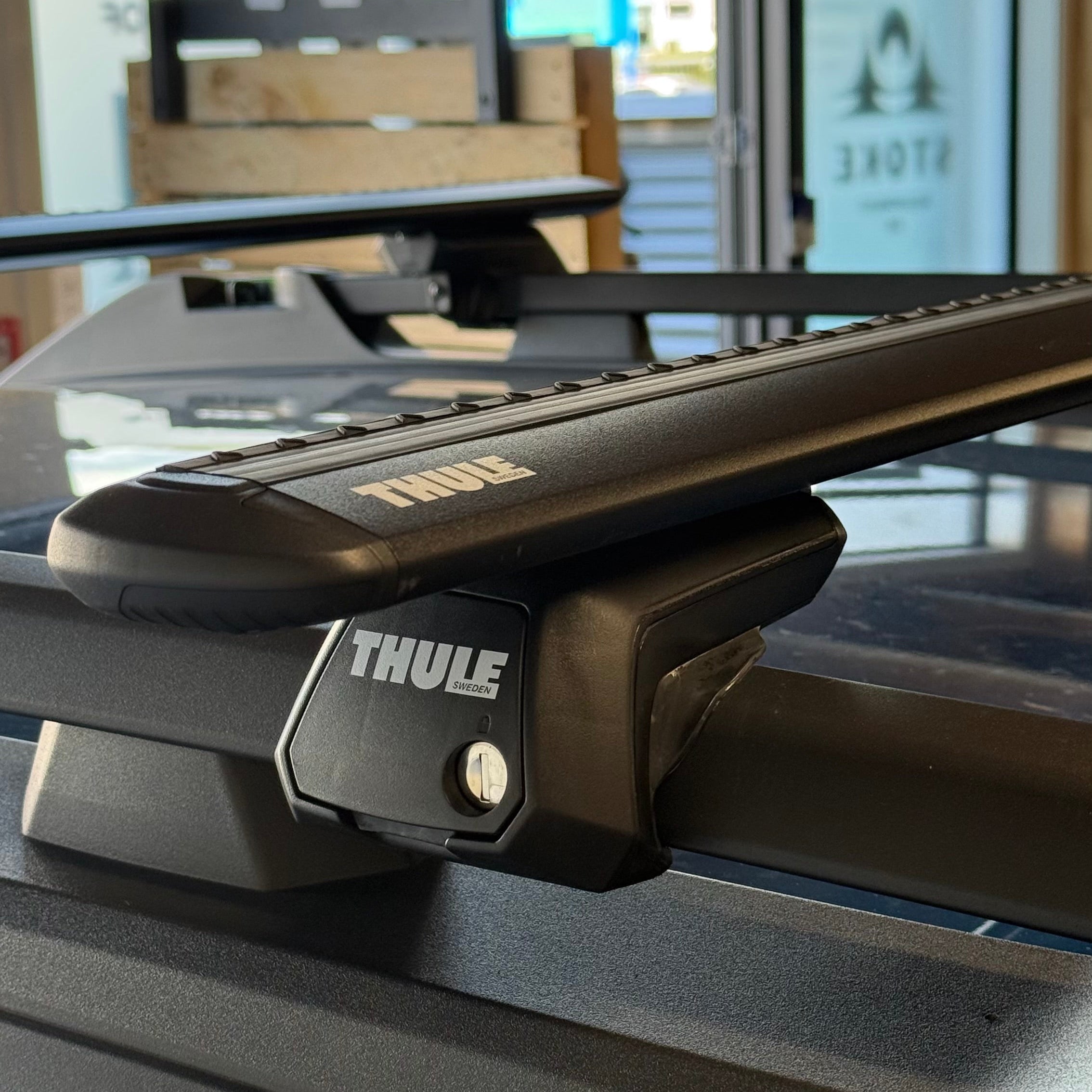 Thule roof rack system on a vehicle with a blurred indoor background
