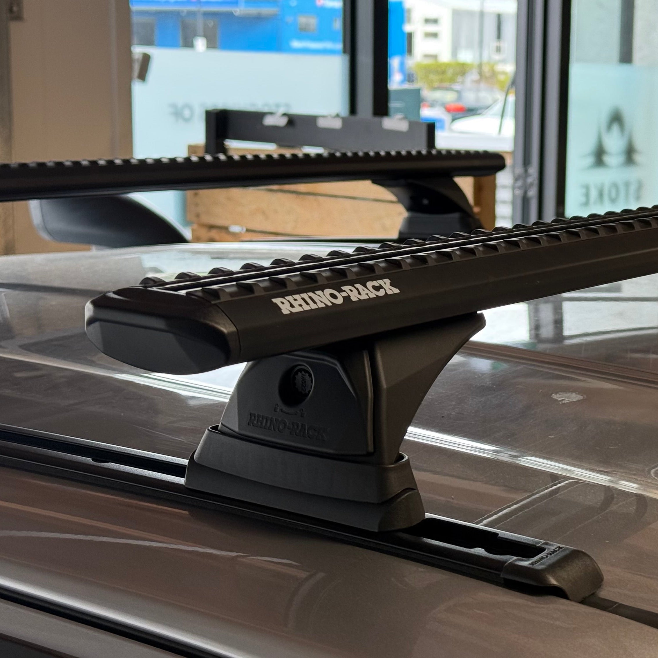 Roof rack system on a vehicle's roof with visible brand name.