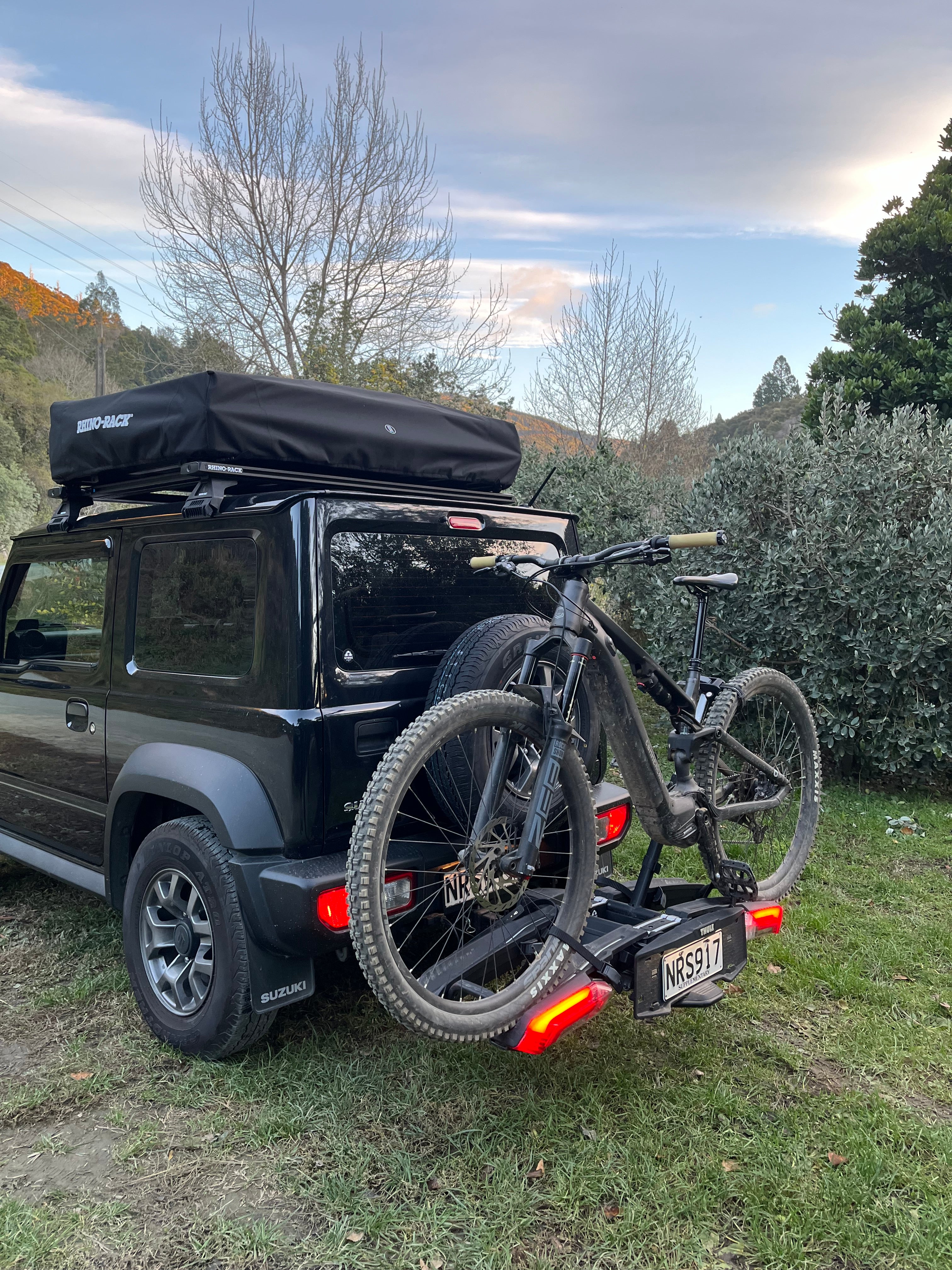 Bicycle attached to a Thule Epos Bike Rack with trees in the background