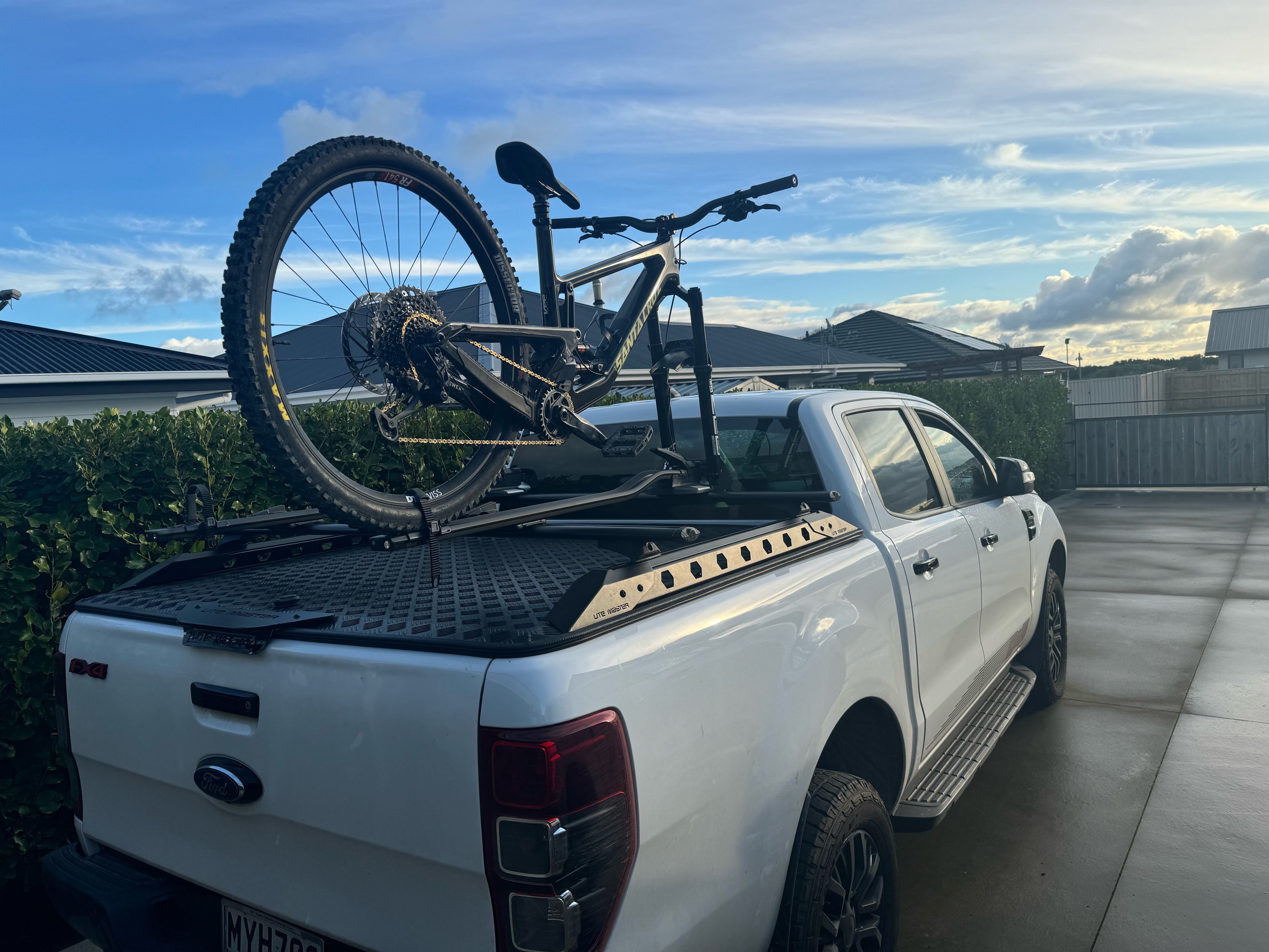 White ford ranger with a thule TopRide bike rack mounted on a rhino-rack hardlid rack system