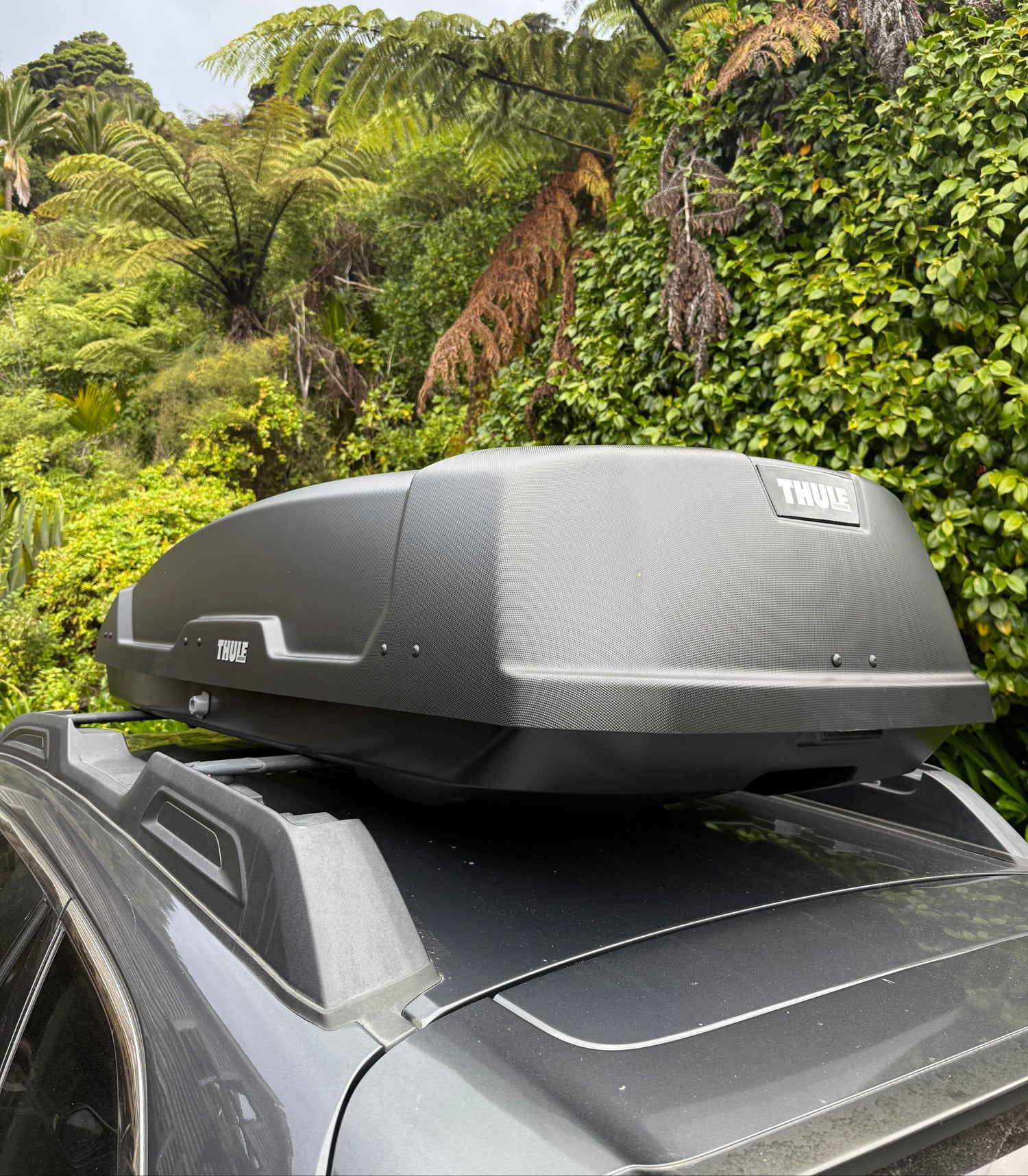 Thule Force XT Roof Box mounted on a Subaru Outback, parked in a Bush Setting with bike gear inside