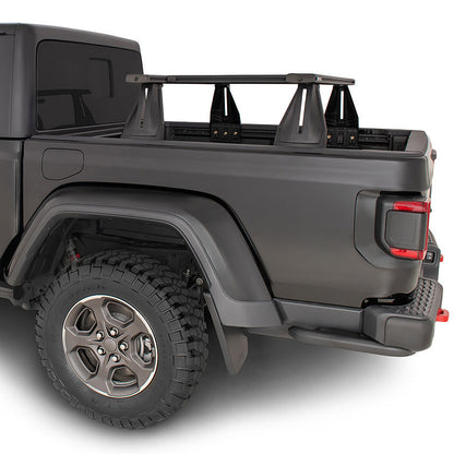 A matte dark gray Jeep Gladiator pickup truck with a black roof rack, shown from a rear three-quarter angle on a white background.
