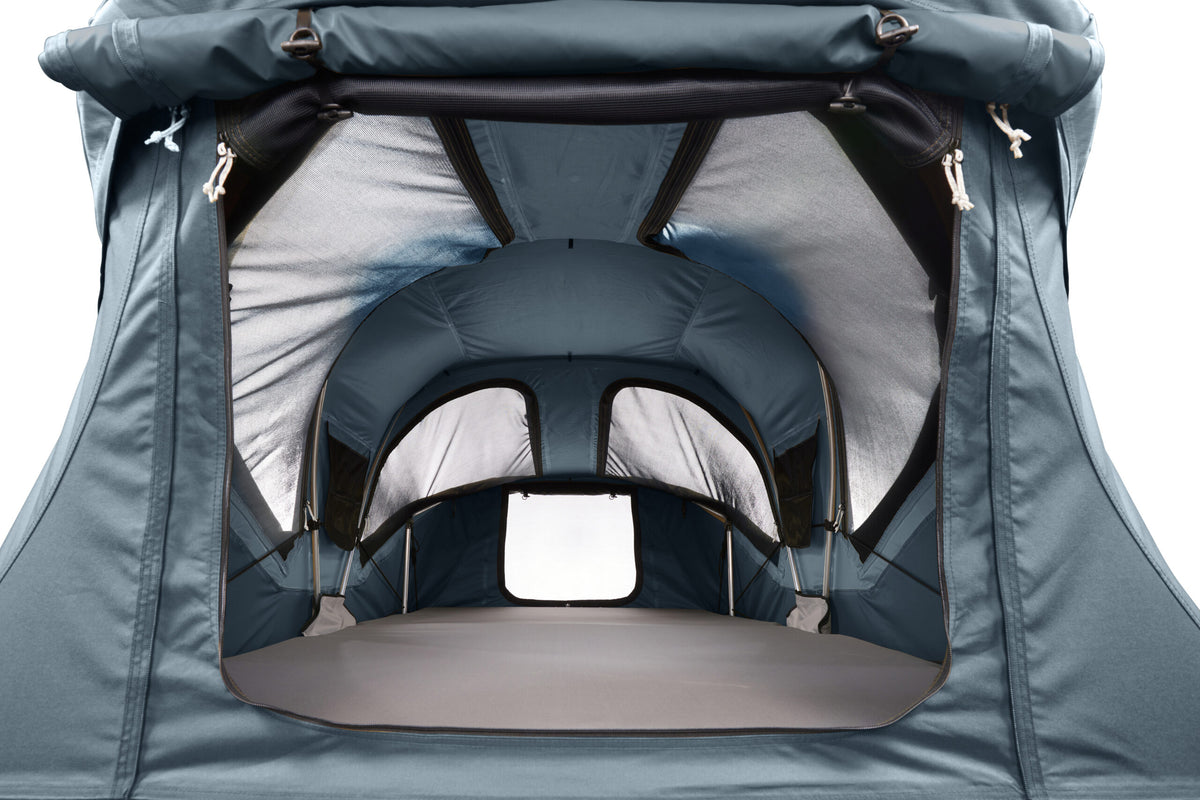Close-up of the interior opening of a dark teal tent or canopy, showing gray and black inner lining, support straps, and a window cutout against a white background.