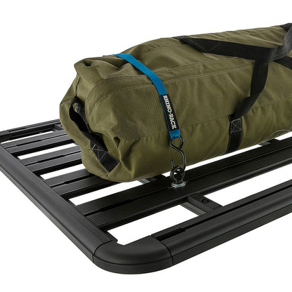 Green roll-up bag on a black roof rack with visible branding.