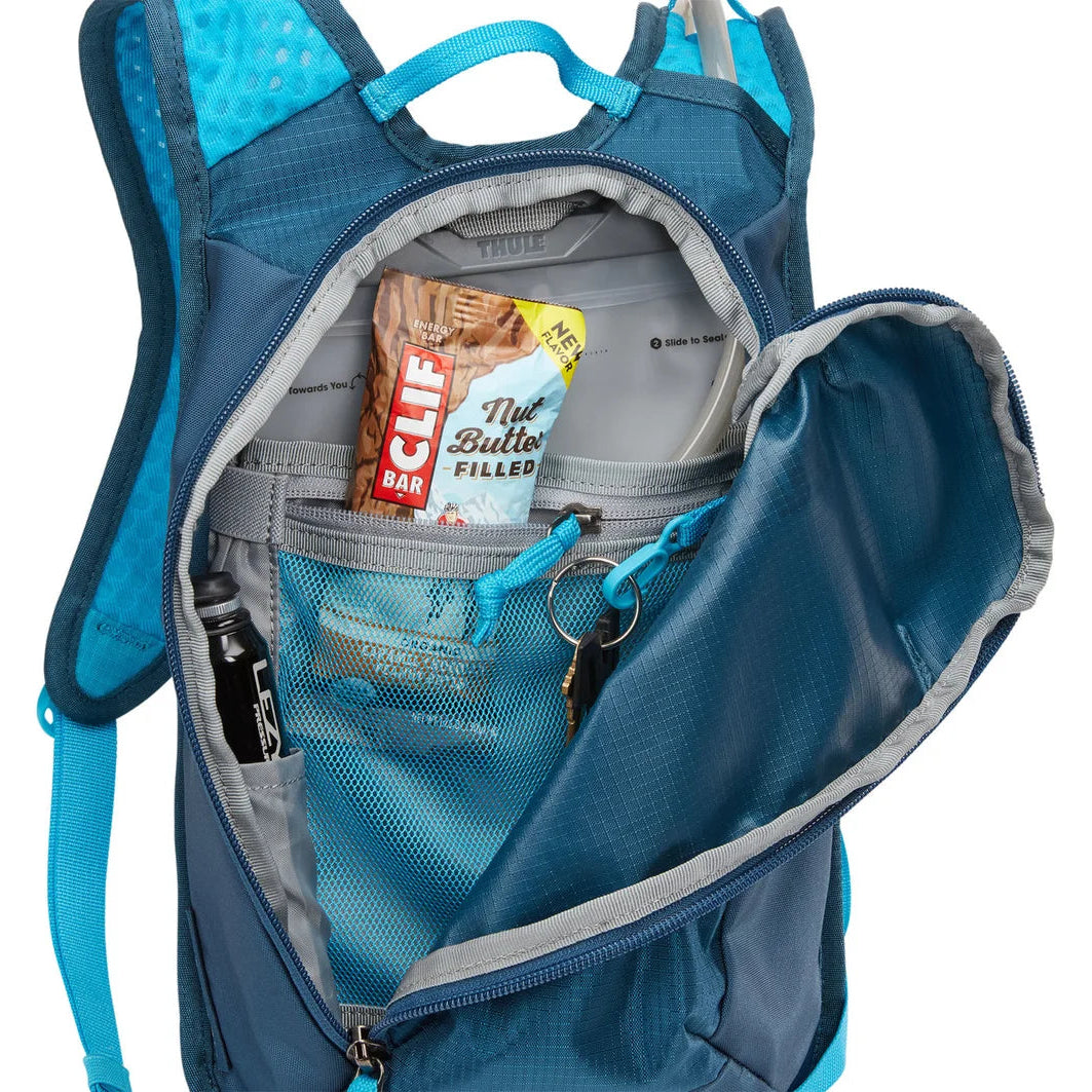 Blue backpack with food items inside on a white background