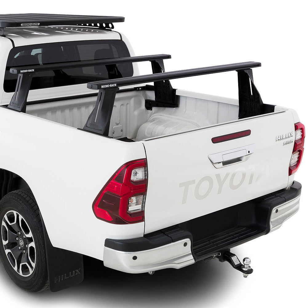 White Toyota pickup truck with roof racks and a bed cover on a white background